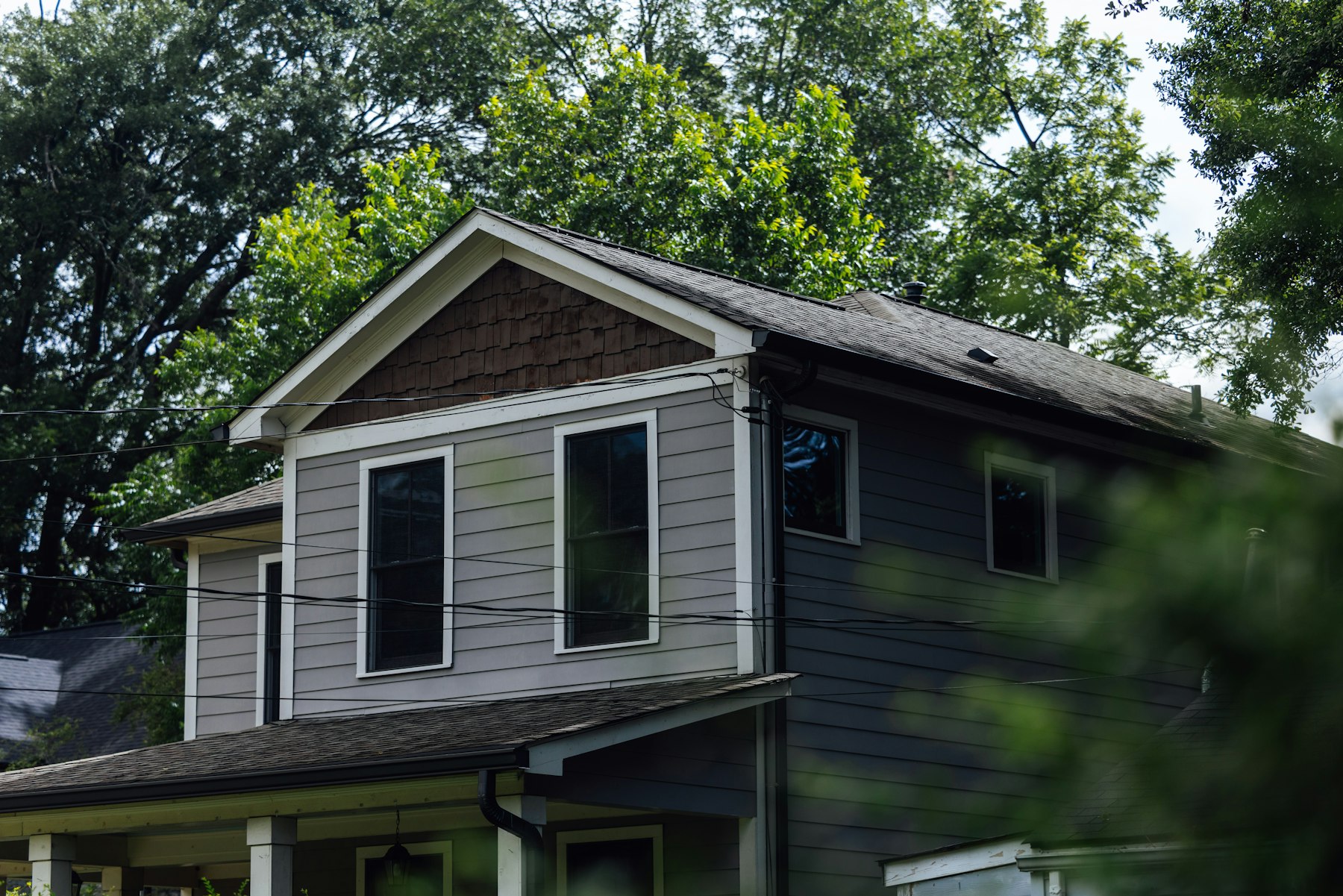 Gray sided house surrounded by trees